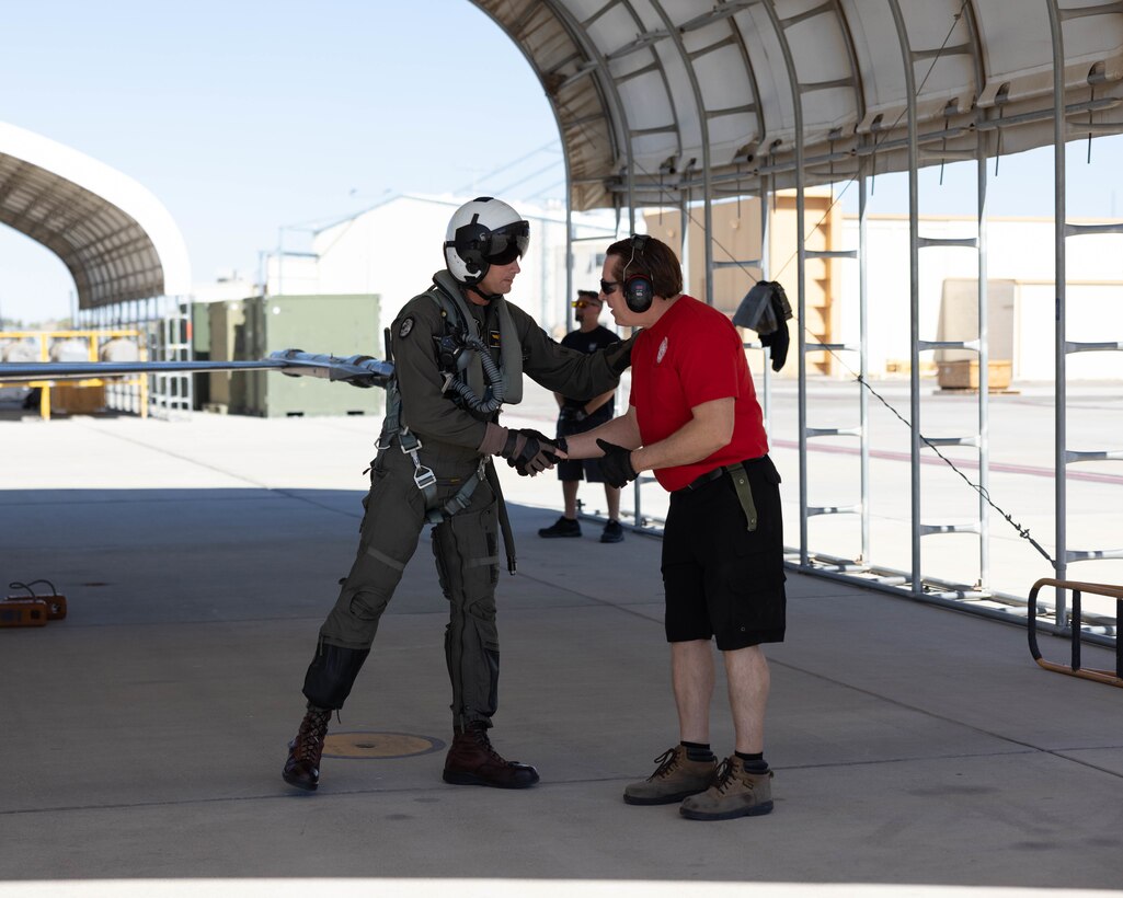 U.S. Marine Corps Lt. Col. Eric Scherrer, commanding officer, Marine Fighter Training Squadron 401 (VMFT-401), Marine Aircraft Group 41, 4th Marine Aircraft Wing, shakes the hand of a maintainer at Marine Corps Air Station Yuma, Arizona, Oct. 28, 2022. VMFT-401 is the only adversary squadron with the mission to act as the opposing force in simulated air combat. (U.S. Marine Corps photo by Lance Cpl. Jade Venegas)