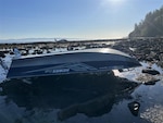 A 15-foot pleasure craft sits capsized at Koitlah Point