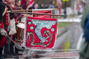 Image of Minuteman reenactors holding a flag.