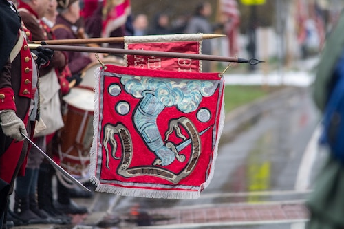 Image of Minuteman reenactors holding a flag.