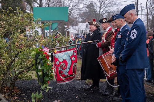 Image of Airmen participating in wreath ceremony with local reenactors.