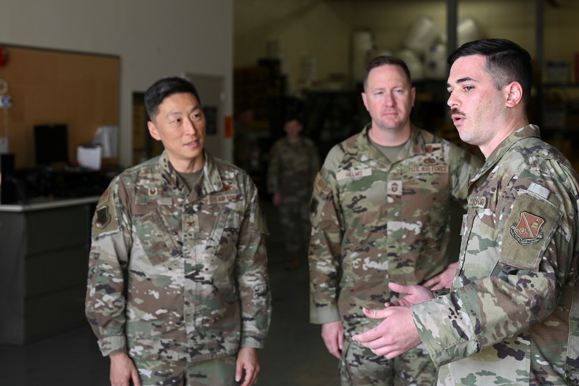 U.S. Air Force Staff Sgt. Matthew T. Haselden, noncommissioned officer in charge of outbound cargo with the 316th Logistics Readiness Squadron, speaks with Col. Jun S. Oh, 316th Wing and installation commander, and Chief Master Sgt. Kevin W. Helms, 316th Wing command chief, during a walk-through of outbound cargo operations at Joint Base Andrews, Md., April 9, 2025. As part of the “Winnin’ Like a Griffin” recognition program, Haselden was recognized for his leadership and technical expertise supporting high-priority cargo missions. (U.S. Air Force photo by Senior Airman Gianluca Ciccopiedi)