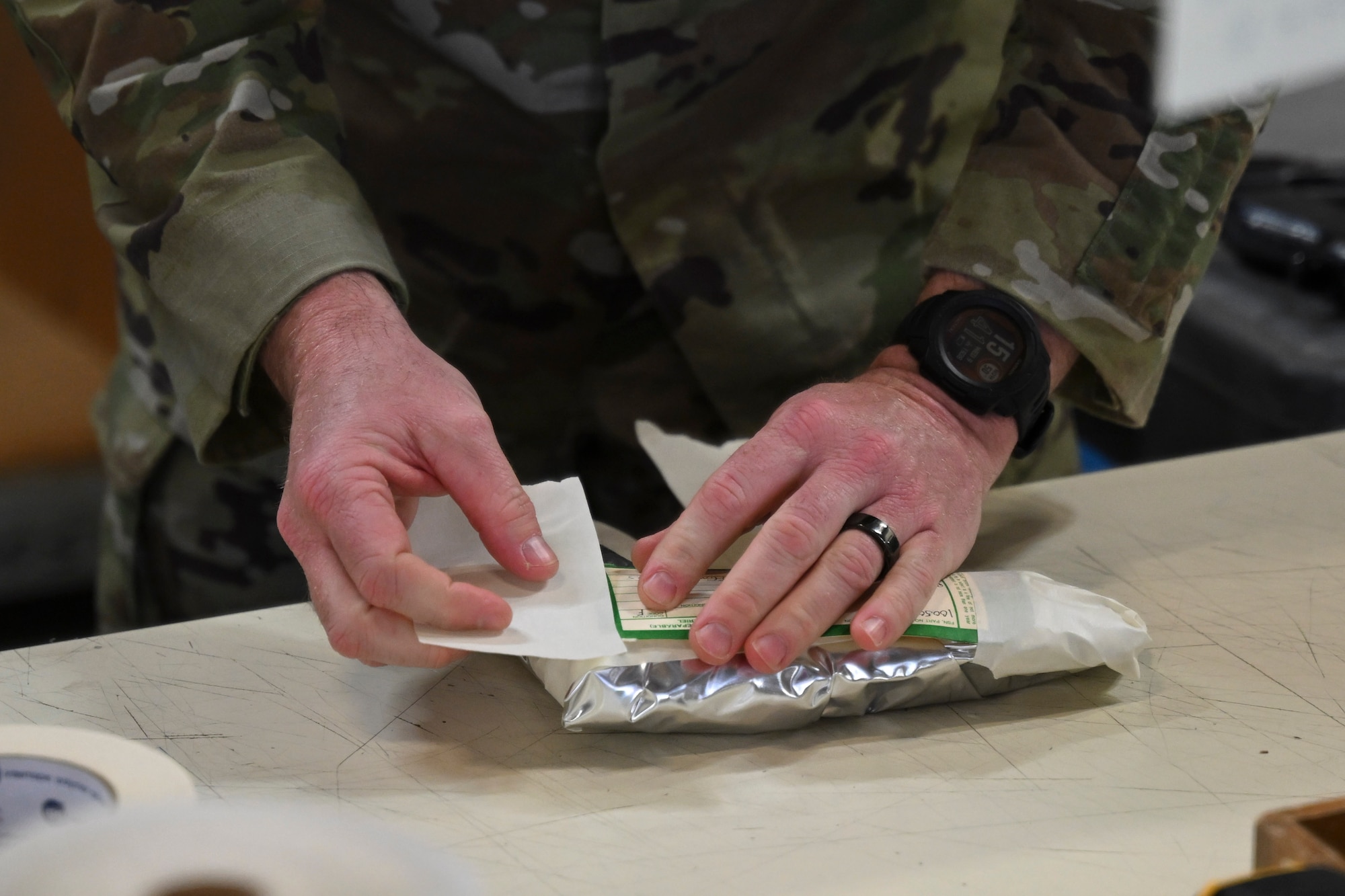 U.S. Air Force Chief Master Sgt. Kevin W. Helms, 316th Wing command chief, secures documentation to a package during a packaging demonstration at Joint Base Andrews, Md., April 9, 2025. The demonstration showcased best practices in handling, securing and preparing sensitive cargo for transport in support of global operations. (U.S. Air Force photo by Senior Airman Gianluca Ciccopiedi)