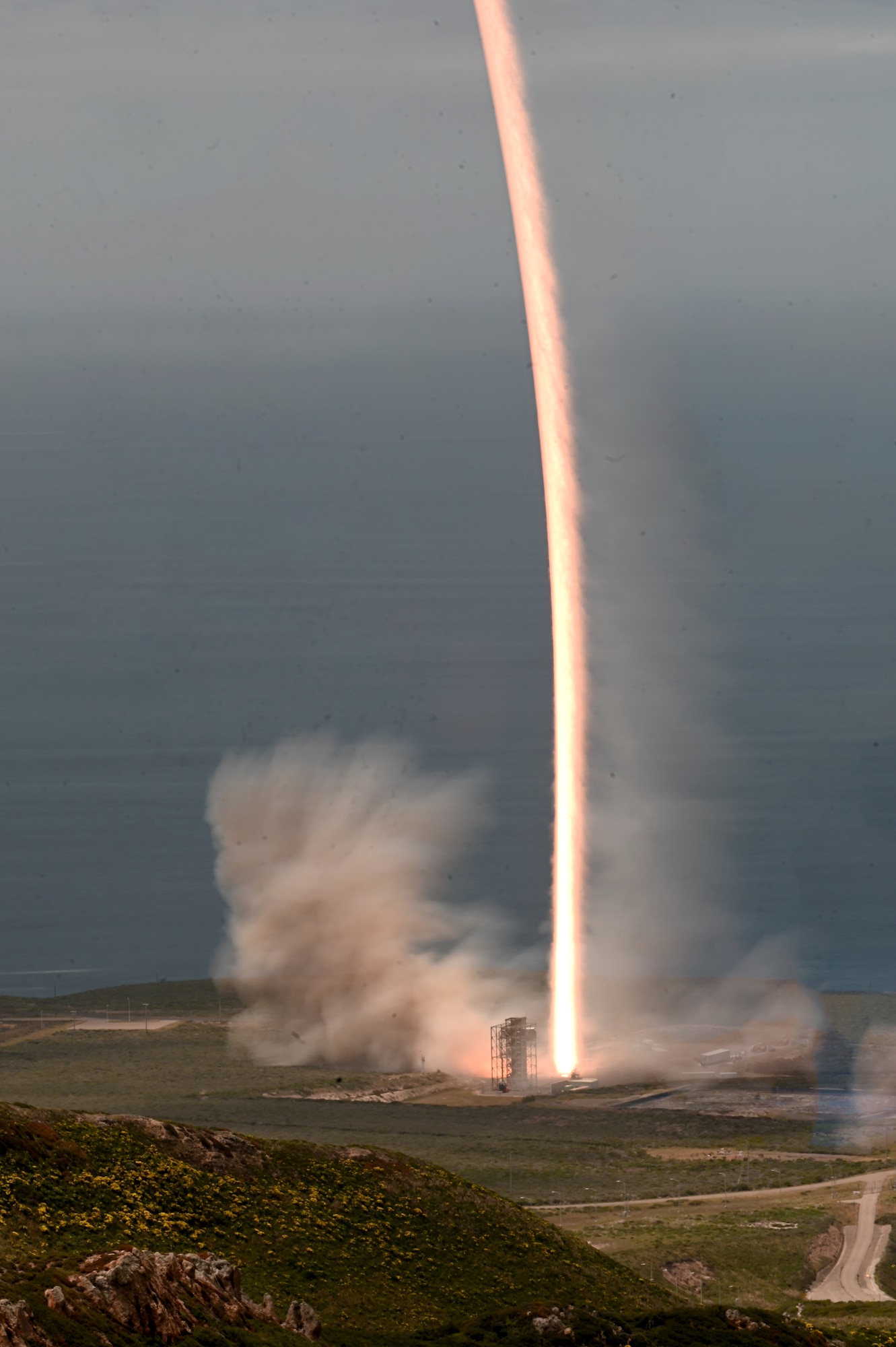 a rocket launches outside on the coastline.