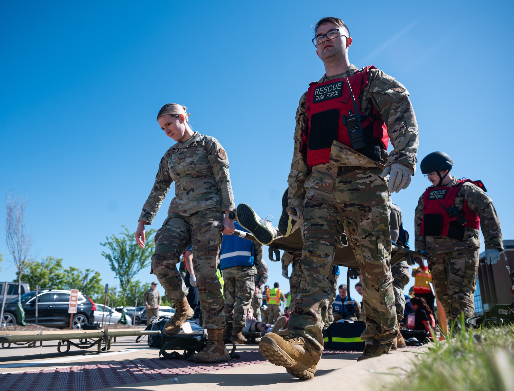 A group of four people carry out an injured person.
