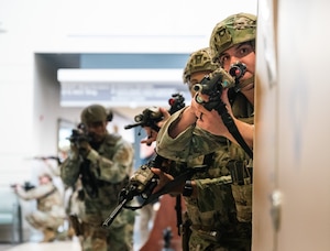 Four men with rifles stand in a line.