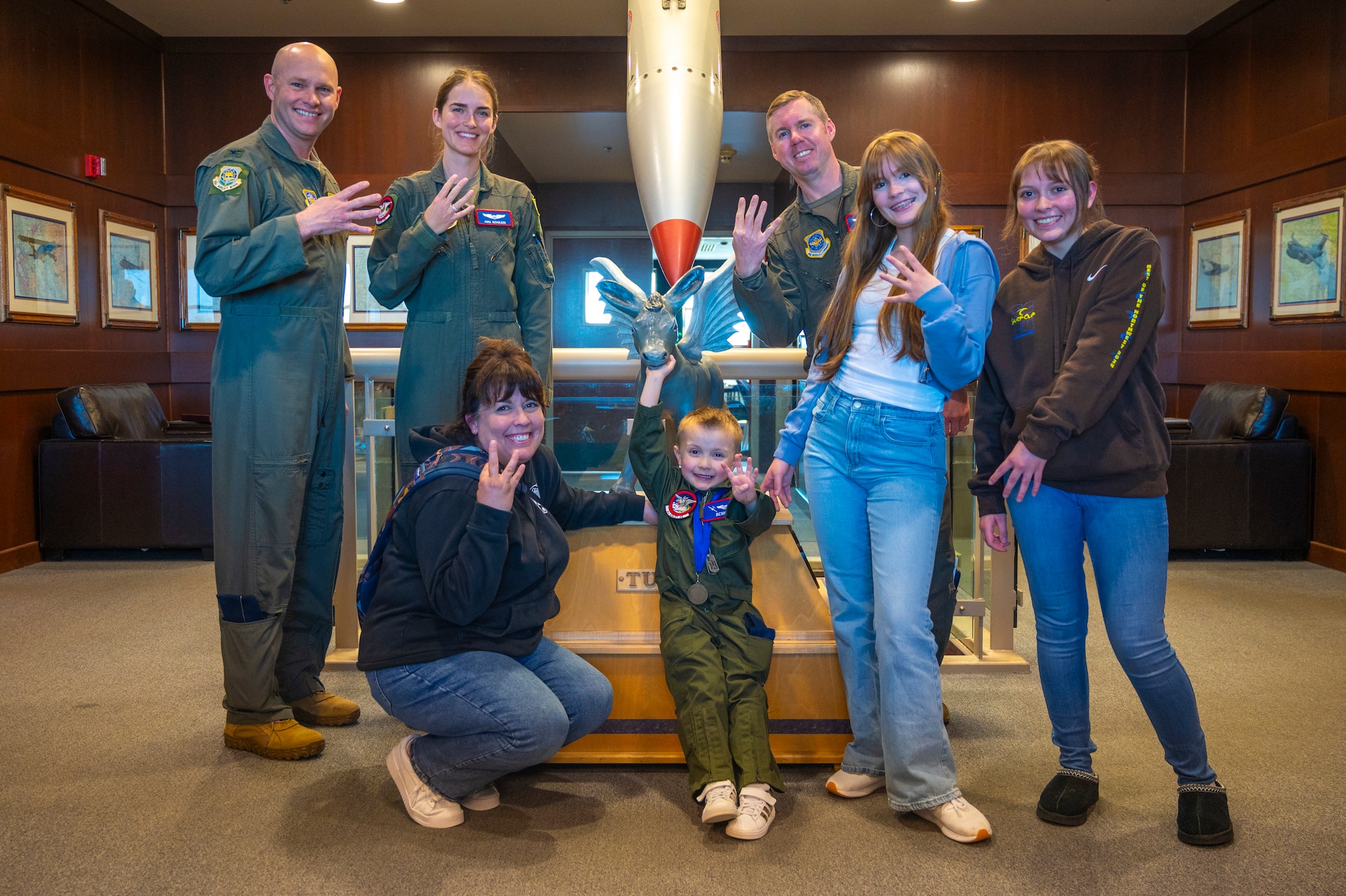 Benny Blankenship, the 2025 Team McChord pilot for a day, and his family stand together with U.S. Air Force Col. John Berger, 62d Airlift Wing deputy wing commander, top left, Capt. Anna Nicholson, 4th Airlift Squadron pilot, top center, and Lt. Col. Bradley Wills, 4th AS commander, top right, at Joint Base Lewis-McChord, Washington, April 17, 2025.