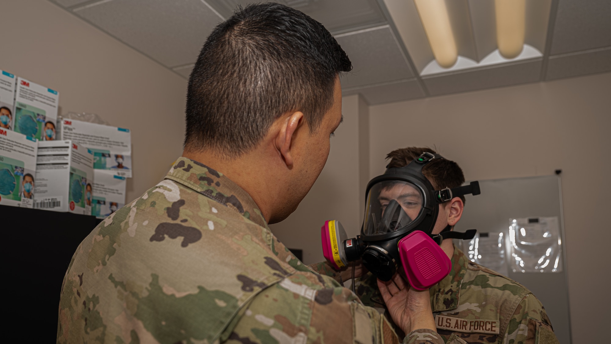 Staff Sgt. Patrick Norindr, bioenvironmental engineering flight chief for the 319th Operational Medical Readiness Squadron, demonstrates a gas mask fitting at Grand Forks Air Force Base, N.D., April 3, 2025. One of Norindr’s responsibilities is conducting gas mask fittings for Airmen preparing to deploy. (U.S. Air Force photo by Airman Nailah Pacheco)