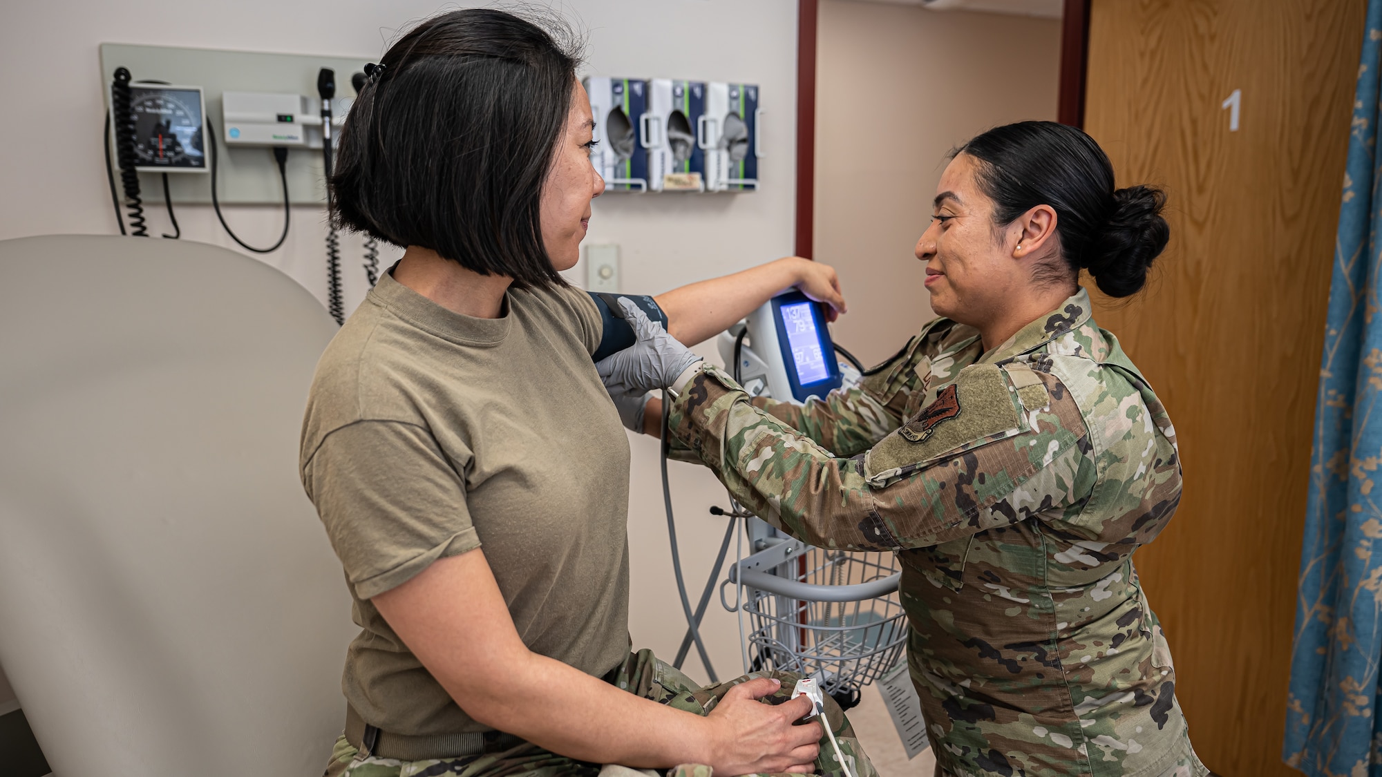 Staff Sgt. Yesica De Leon, non-commissioned officer in charge of the Warrior Operational Medicine Clinic for the 319th Operational Medical Readiness Squadron takes Capt. Holly Prouty’s, Aerospace Medicine Flight Commander for the 319th Operational Medical Readiness Squadron’s blood pressure at Grand Forks Air Force Base, N.D., April 3, 2025. De Leon was selected for the Nurse Enlisted Commissioning Program that allows enlisted airmen to complete their Bachelors of Science in Nursing while remaining on active duty and receive a commission as an active duty nurse. (U.S. Air Force photo by Airman Nailah Pacheco)