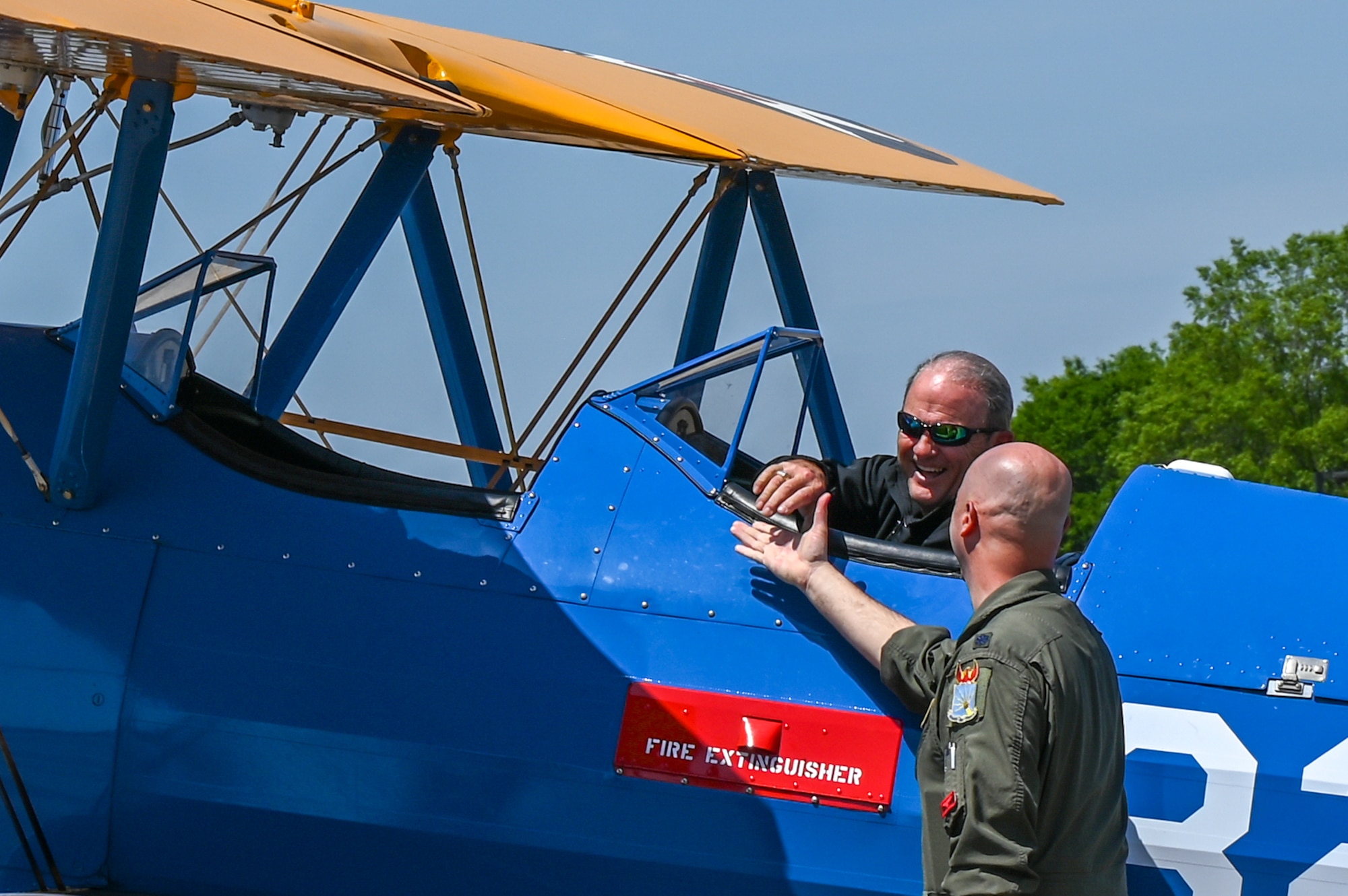 U.S. Air Force Lt. Col. Matt Ziemann, Air Command and Staff College Department of Leadership instructor, reaches out to shake the hand of Butch Cole, Commemorative Air Force PT-17 Stearman pilot, at Maxwell Air Force Base, Alabama, April 17, 2025.