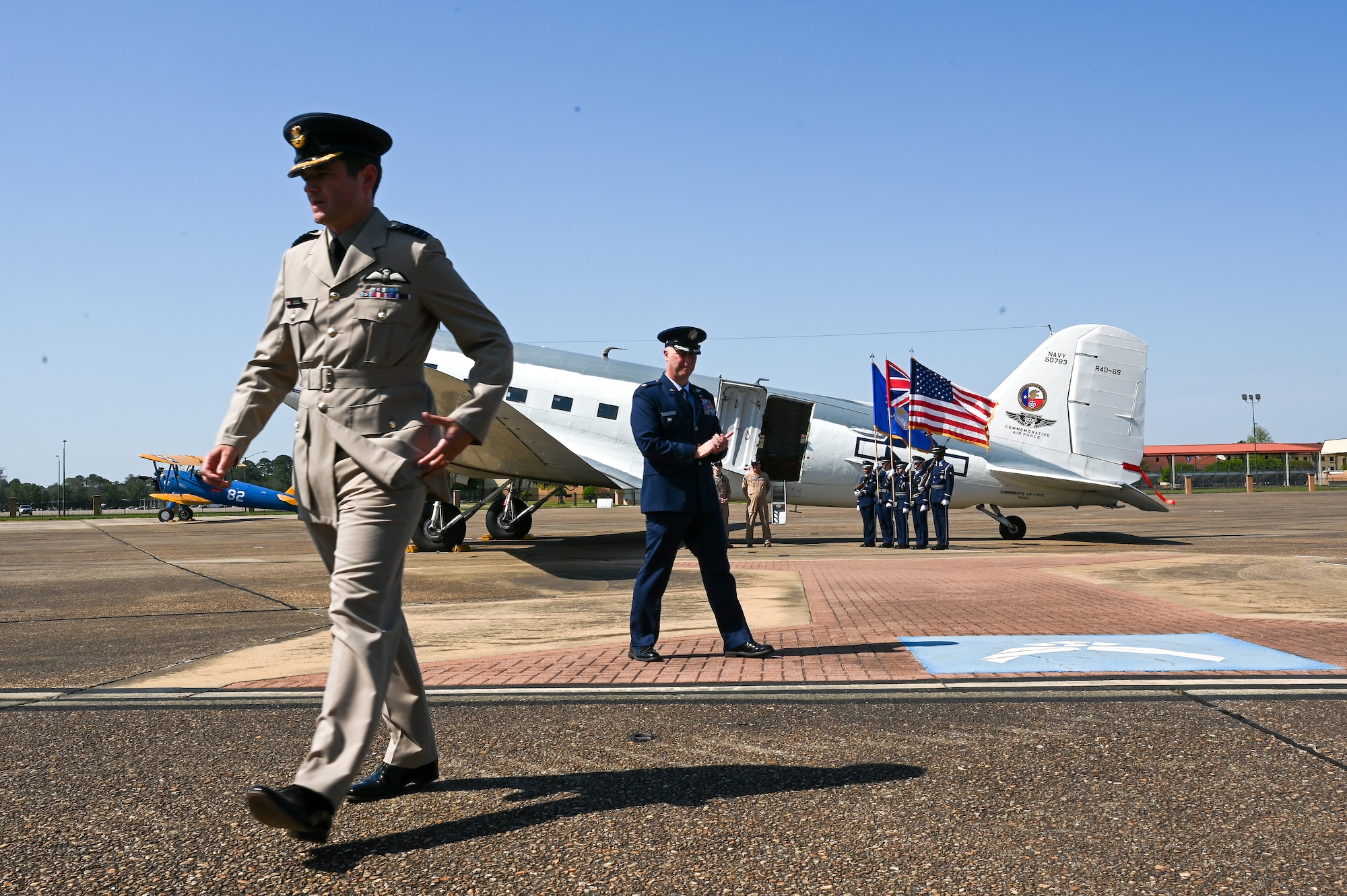 Royal Air Force Group Capt. Tim Brookes, Air War College, left, and U.S. Air Force Lt. Col. Matt Ziemann, Air Command and Staff College Department of Leadership instructor, right, walk on the flight line at Maxwell Air Force Base, Alabama, April 17, 2025.