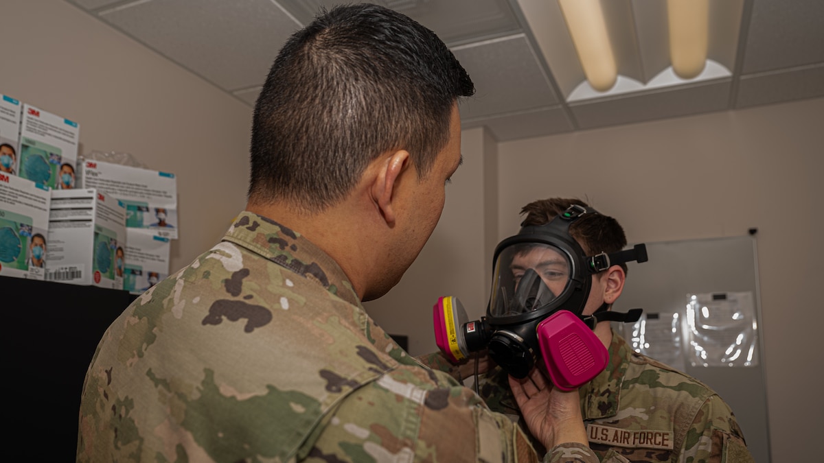 Staff Sgt. Patrick Norindr, bioenvironmental engineering flight chief for the 319th Operational Medical Readiness Squadron, demonstrates a gas mask fitting at Grand Forks Air Force Base, N.D., April 3, 2025. One of Norindr’s responsibilities is conducting gas mask fittings for Airmen preparing to deploy. (U.S. Air Force photo by Airman Nailah Pacheco)
