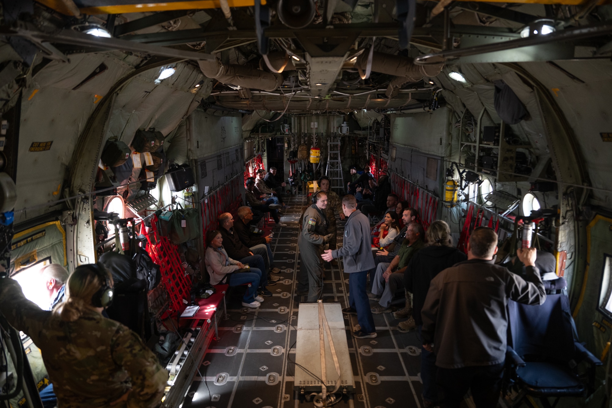 A group of people in the back of a military aircraft.