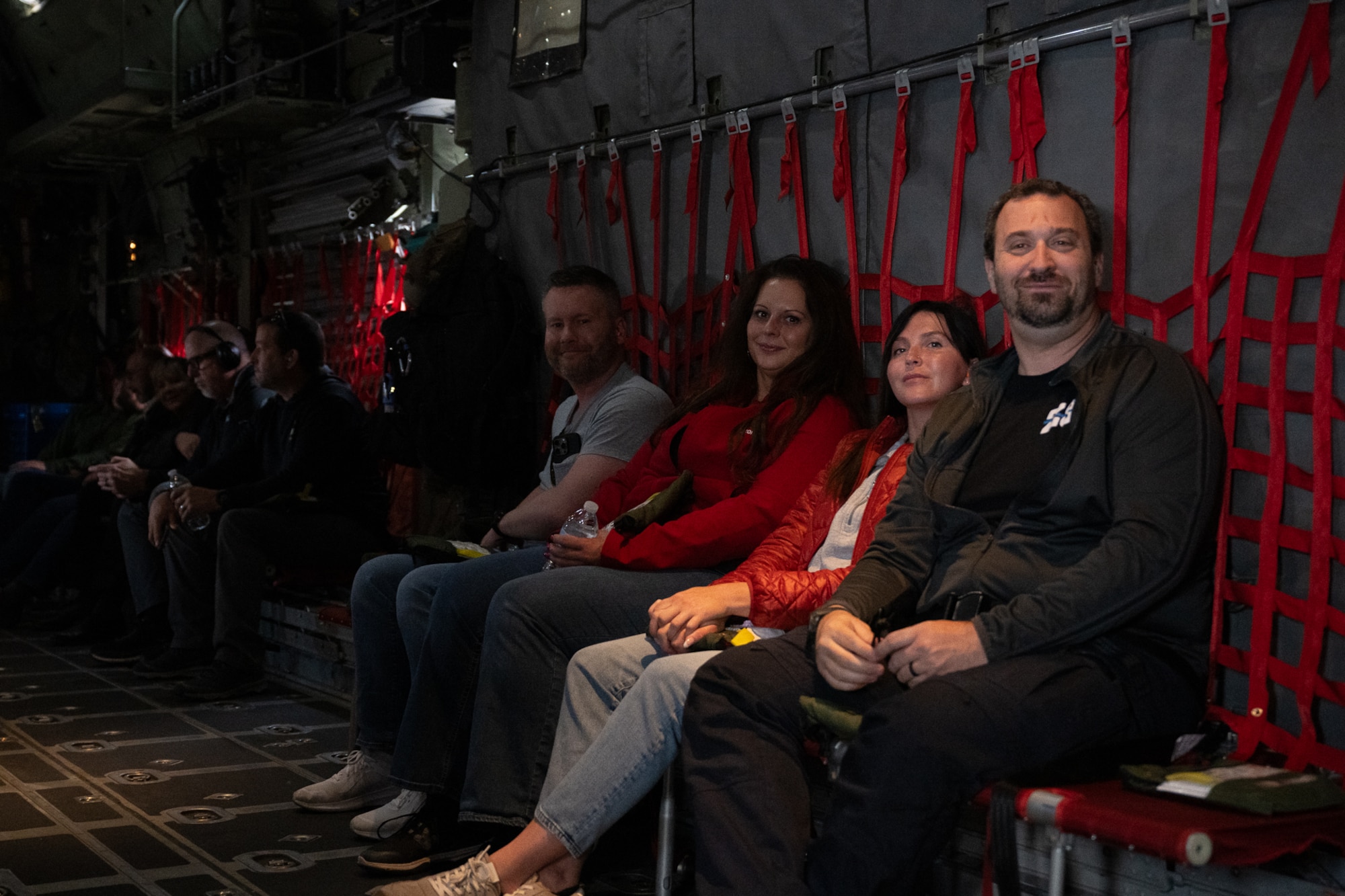 A group of people sitting in chairs in a military aircraft.