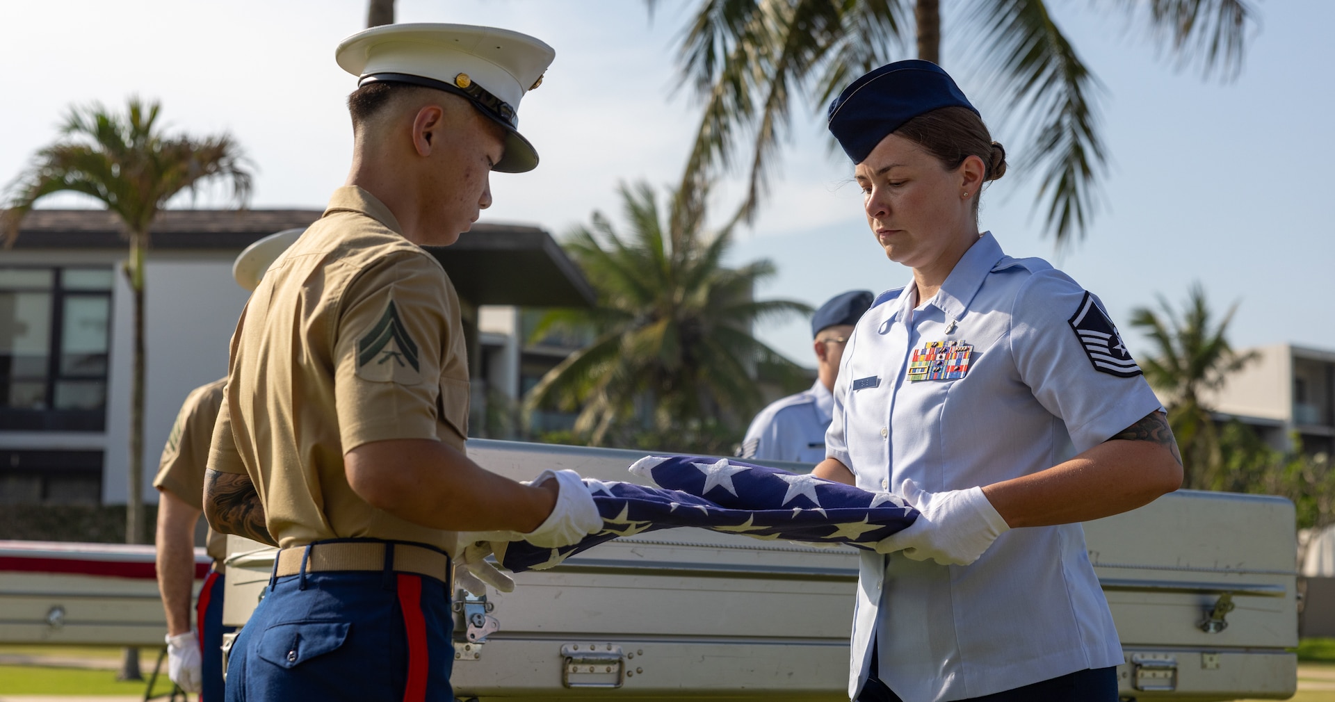 U.S. Marine Corps Cpl. Kevin Nguyen, recovery noncommissioned officer and short-term individual augmentee, Defense POW/MIA Accounting Agency, and U.S. Air Force Master Sgt. Allison Meaney, team medic and short-term individual augmentee, DDPAA, prepare to drape a flag during a repatriation ceremony in Vietnam, April 19, 2025.
