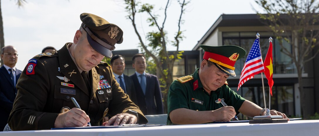 U.S. Army Lt. Col. Travis Walter, Defense POW/MIA Accounting Agency Detachment 2 commander, and General Nguyen Ba Thang, Vietnamese Office for Seeking Missing Persons, sign transfer documents before a repatriation ceremony in Vietnam, April 19, 2025.