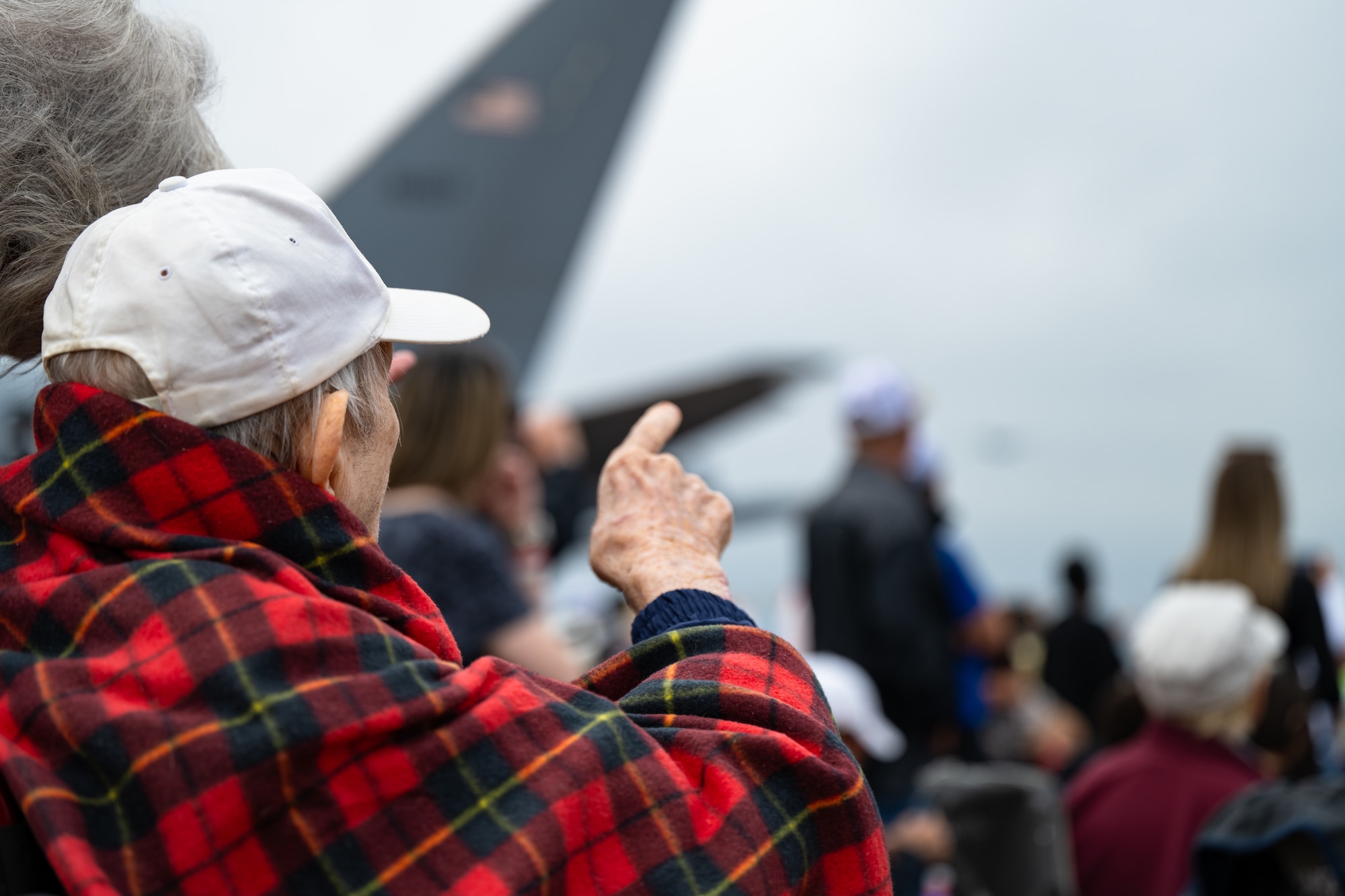 a man points to the sky during and airshow