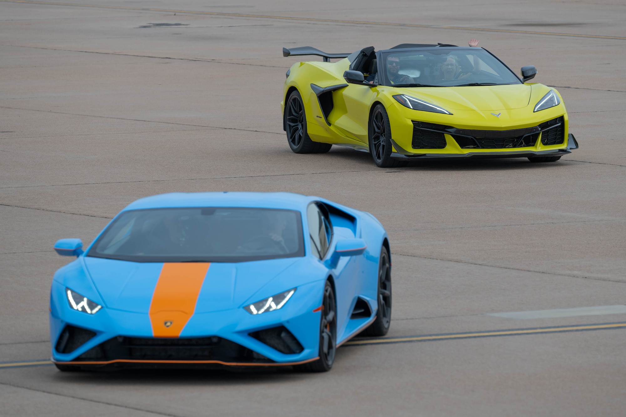 two sports cars drive on the flightline