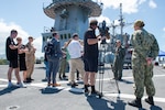 CAIRNS, Australia (April 16, 2025) – Capt. Nicholas DeLeo, commanding officer of the U.S. 7th Fleet flagship USS Blue Ridge (LCC 19), speaks with members of the Australian media on the ship’s flight deck during a scheduled port visit in Cairns, Australia, April 16, 2025. The Blue Ridge and embarked U.S. 7th Fleet staff conduct regular Indo-Pacific patrols to deter aggression, strengthen alliances and partnerships, and advance future warfighting capabilities. (U.S. Navy photo by Mass Communication Specialist Seaman Nicholas Douglass.)