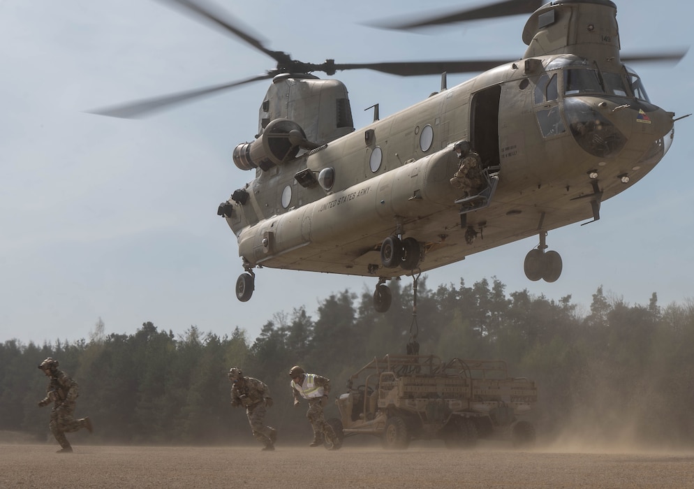 Three airman run away from a sling load operation