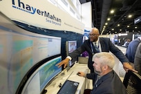 Jeff Harris (left), U.S. Naval Research Laboratory (NRL) senior test engineer, discusses autonomous vessel and acoustic detections with Andrew Stockwell, Thayer Mahan director of acoustic analysis, at the 2025 Sea Air Space expo in National Harbor, Md. April 7, 2025. NRL and Thayer Mahan have partnered on a new unmanned sonar technology to improve maritime domain awareness. (U.S. Navy photo by Sarah Peterson)