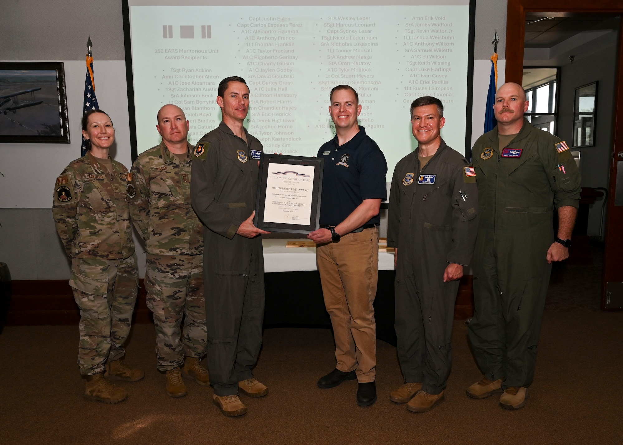 Col. Cory Damon, 22nd Air Refueling Wing commander, presents former 350th Expeditionary Air Refueling Squadron leadership with the Meritorious Unit Award at McConnell Air Force Base, Kansas, April 17, 2025. The 350th EARS offloaded 87.2 million pounds of fuel during their 6-month deployment. (U.S. Air Force photo by Senior Airman Paige Weldon)