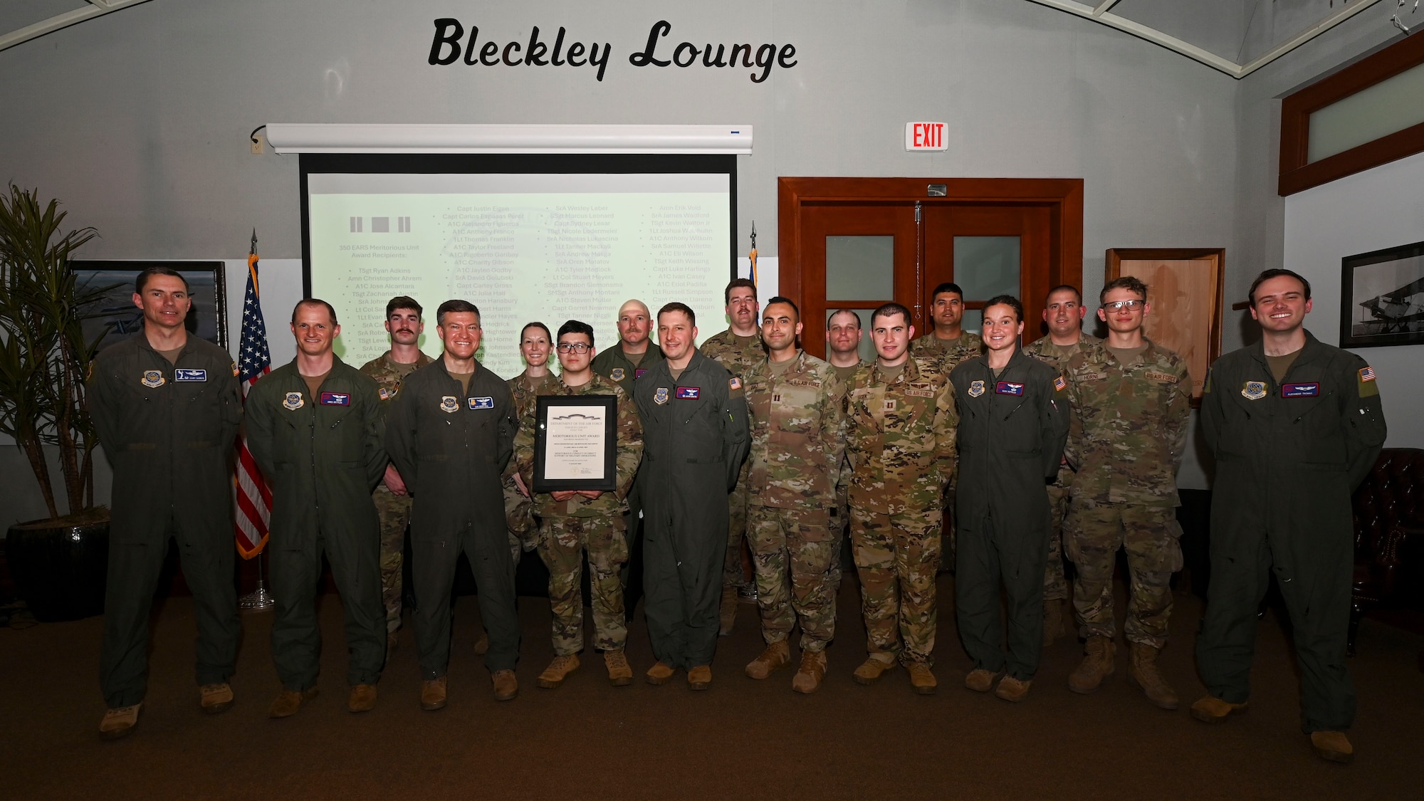 Former members of the 350th Expeditionary Air Refueling Squadron pose with their Meritorious Unit Award at McConnell Air Force Base, Kansas, April 17, 2025. The group consisted of Airmen from the 350th Air Refueling Squadron and 722nd Aircraft Maintenance Squadron. (U.S. Air Force photo by Senior Airman Paige Weldon)