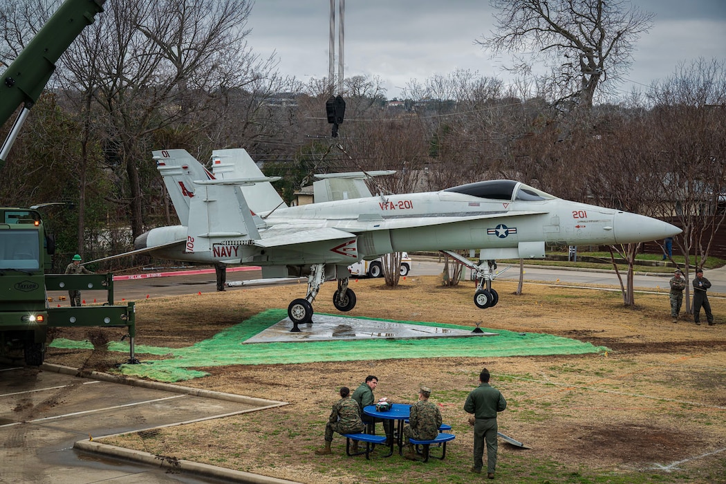 Marines from MWSS 473 Detachment Bravo hoisting F/A-18A into place at its new location at Westworth Village City Hall.