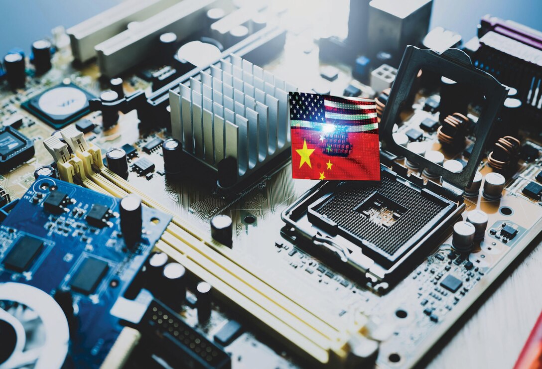 Chip shortage and US-China trade conflict. Global chip shortage crisis and China-United States trade war concept. China flag and US flag on computer on chip electronic circuit board. Computer hardware.