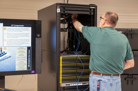 A man is pictured standing at a server rack.