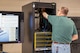 A man is pictured standing at a server rack.