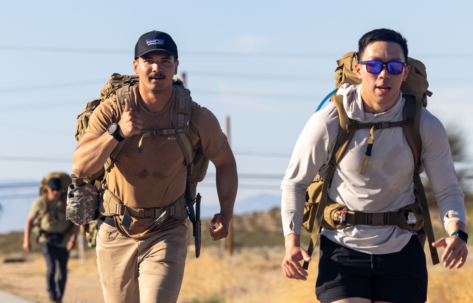 Staff Sgt. Thomas Moriarty, 812th Civil Engineer Squadron, gives a “thumbs up” alongside Senior Airman Ivan Lau, also from 812th CES, as they participate in a commemorative Bataan Death March on Edwards Air Force Base, California, April 12. (Air Force photo by Jennifer Healy)