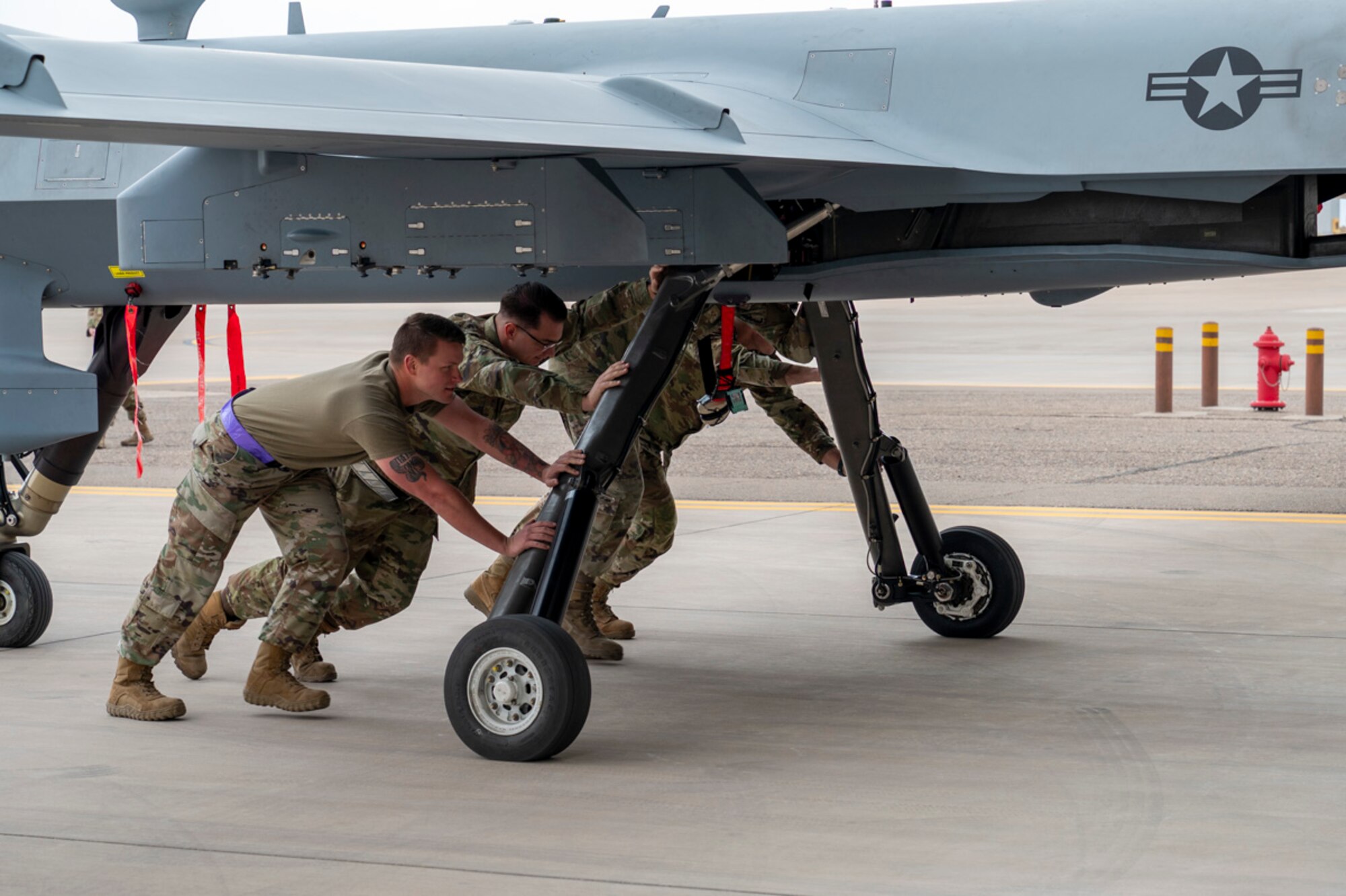 Airmen with the 49th Logistics Readiness Squadron, the 49th Aircraft Maintenance Squadron, and the 849th AMXS push an MQ-9 Reaper after deployment exercise Project Iron Agility at Holloman Air Force Base, New Mexico, April 3, 2025. Aligned with the Agile Combat Employment concept, Project Iron Agility trains Airmen to operate under austere and evolving conditions, emphasizing quick decision-making and decentralized command. (U.S. Air Force photo by Senior Airman Michelle Ferrari)
