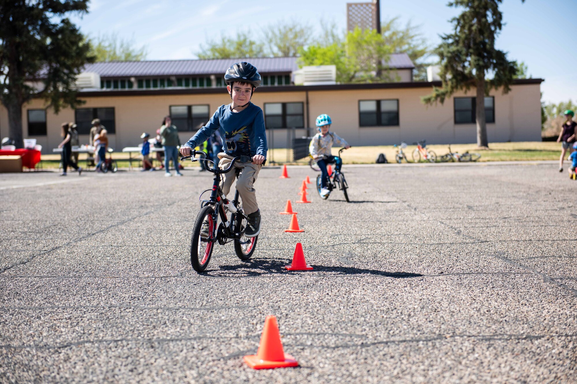 Kids ride bikes through obstacle course