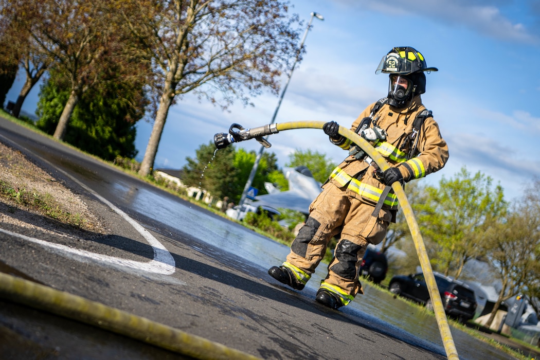 A Fire Fighter pulls on a hose to extend it.