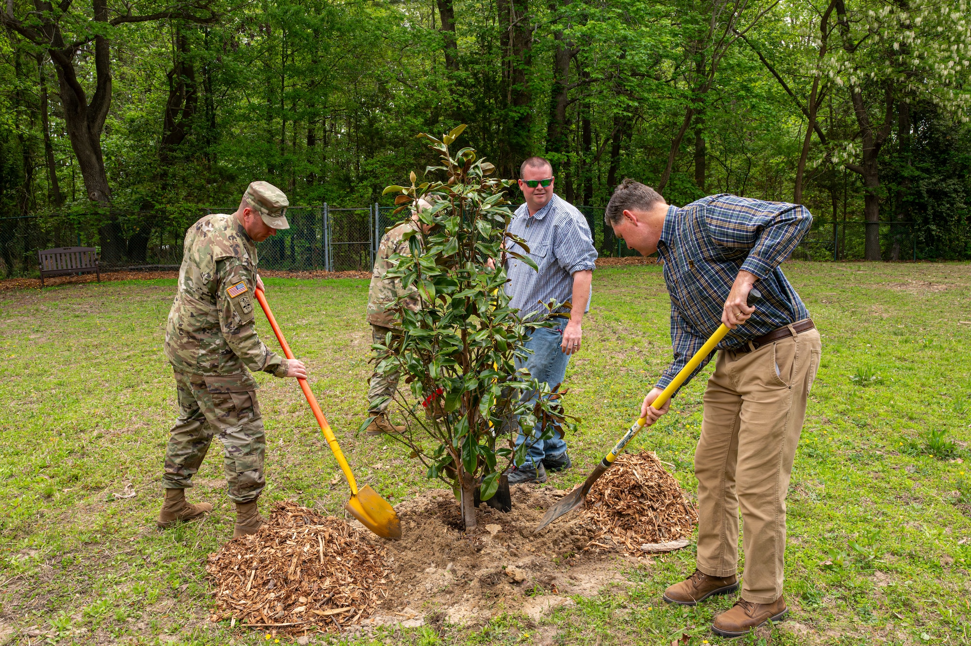 Army Command Sgt. Maj. Jarred Matthews and Donald Calder plant a Red Mulberry tree for Arbor Day at Joint Base Langley-Eustis