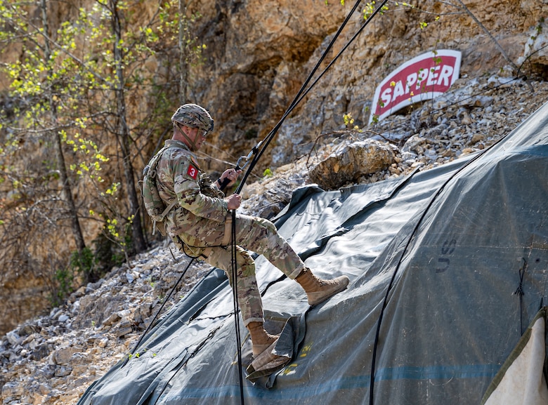 a Soldier is seen repelling down a cliff.
