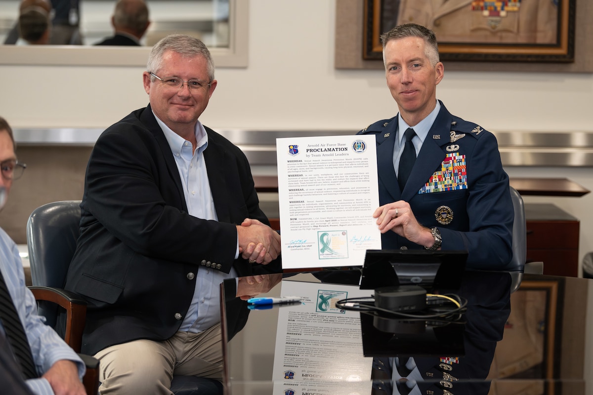 Arnold Engineering Development Complex Commander Col. Grant Mizell, right, and Gary Johnson, sexual assault response coordinator at Arnold Air Force Base, Tenn., display a proclamation signed by each March 28, 2025, recognizing April as Sexual Assault Awareness and Prevention Month across AEDC. Arnold AFB is the headquarters of AEDC. (U.S. Air Force photo by Keith Thornburgh)