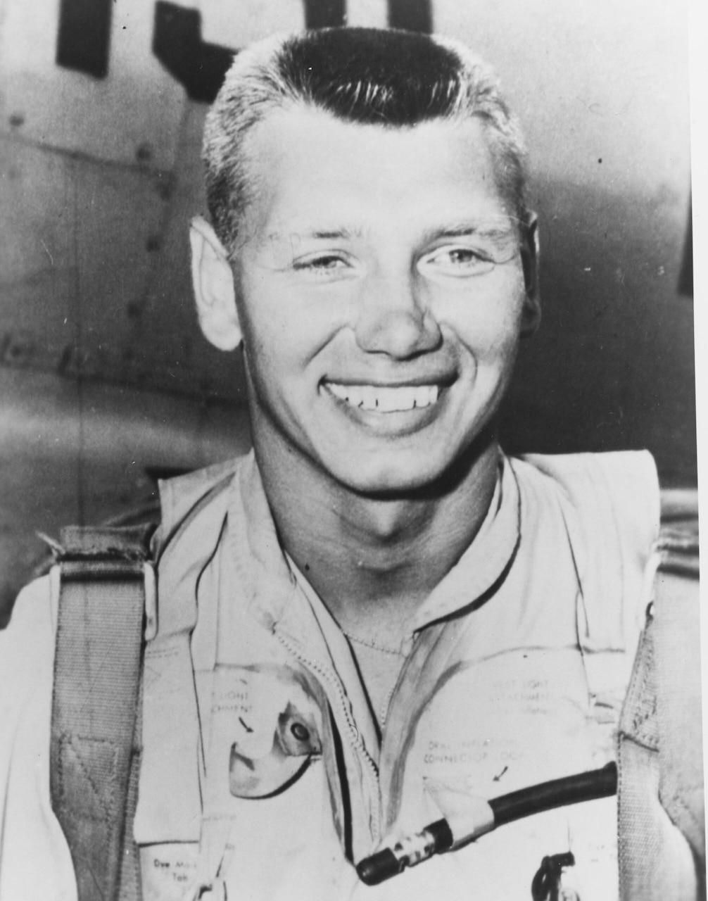 A man in flight gear smiles.