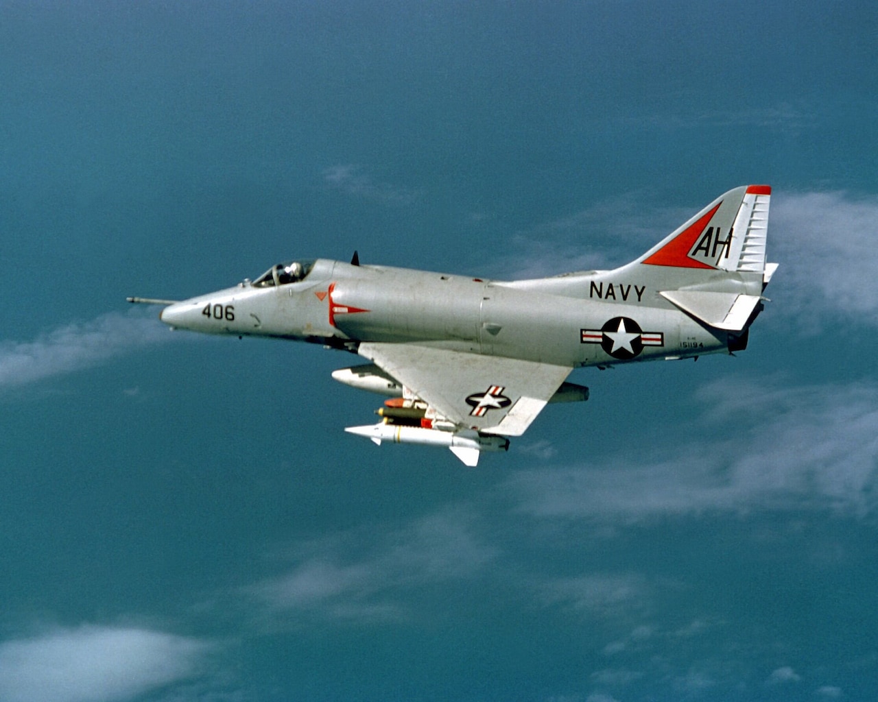 A jet aircraft that says "Navy" on the side flies in the air.
