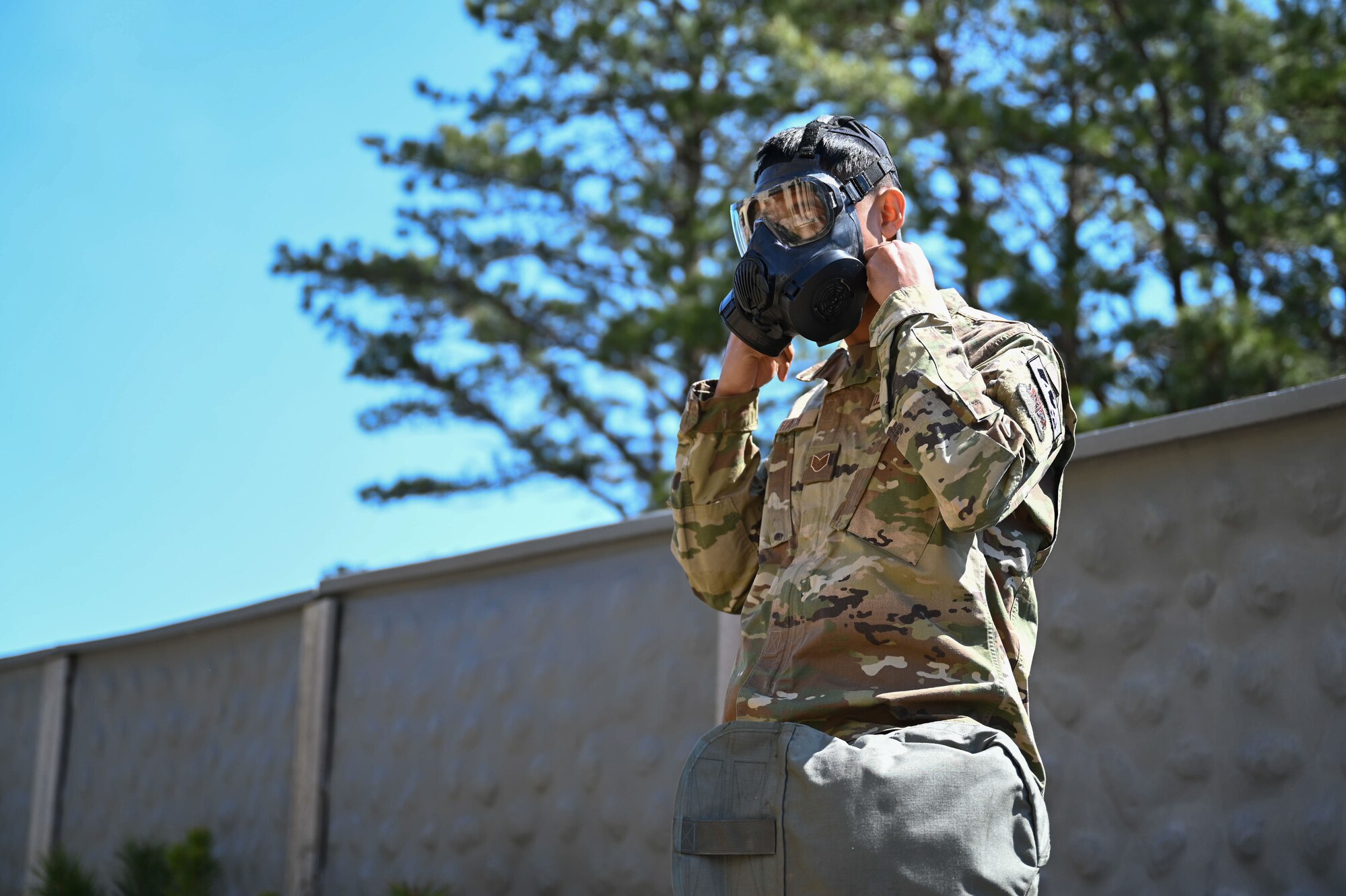 Airman puts on a gas mask.