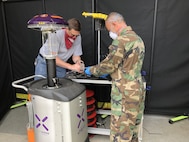 Principal Investigator of the U.S. Naval Research Laboratory (NRL) Navy Coronavirus Rapid Response Team (NCR2T) Team, Brett M. Huhman, Ph.D., P.E. from the Advanced Pulsed Systems Section and former NRL Engineering Technician Mike Jabari prepare a Xenon source for evaluation testing. Designed for whole-room disinfection, the team determined how effective the source would be from a light perspective, and Naval Surface Warfare Center Dahlgren Division followed up with a site visit to perform biological efficacy testing in the Ultraviolet Characterization Lab at NRL-DC Headquarters, May 2020. (U.S. Navy photo)