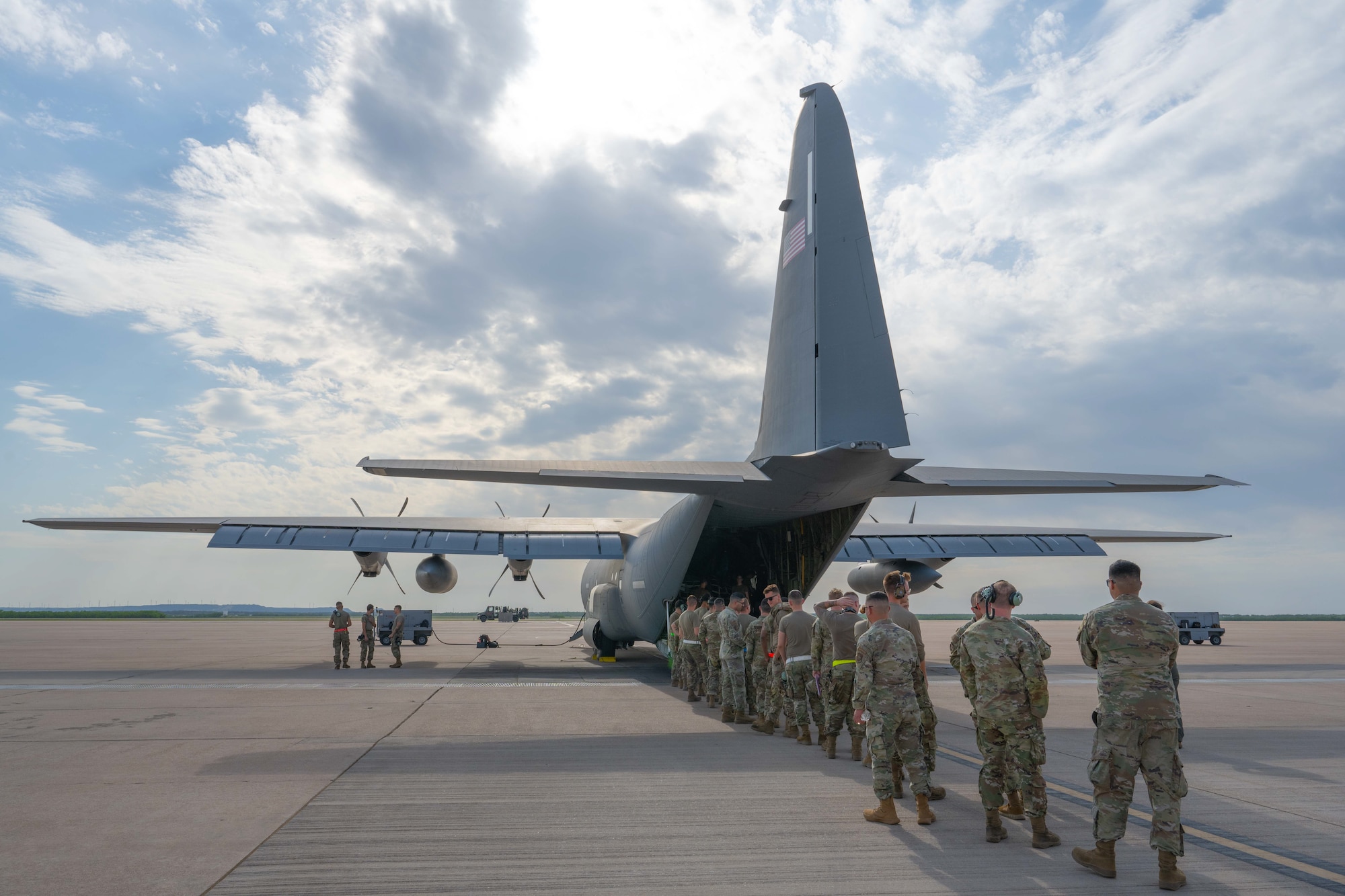 Airmen with the 317th Airlift Wing prepare for a Max Endurance Operation outside a C-130J Super Hercules equipped with external fuel tanks enroute to support Exercise Balikatan 25 at Dyess Air Force Base, Texas, April 17, 2025. Balikatan is a longstanding annual exercise between the Armed Forces of the Philippines and U.S. military designed to strengthen our ironclad alliance, improve our capable combined force, and demonstrate our commitment to regional security and stability. (U.S. Air Force photo by Airman Caleb Schellenberg)