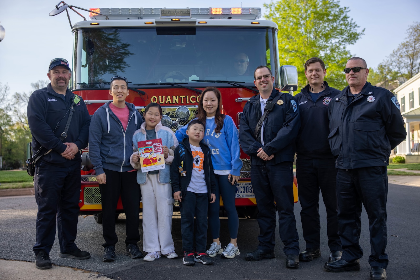 Quantico Fire and Emergency Services personnel pose for a photo with Hyunah Oh during a fire truck ride on Marine Corps Base Quantico, Virginia, Apr. 18, 2025. Quantico Fire and Emergency Services hosted a fire truck ride for winners of the 2024 Fire Prevention Week Coloring contest. The fire truck picked up the students from their base address and drove them to Crossroads Elementary School. (U.S. Marine Corps photo by Lance Cpl. Federico Marquez)