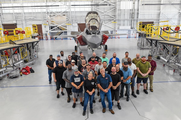 Personnel from the Fleet Readiness Center Southeast (FRCSE) F-35 aircraft production line stand in front of a recently inducted F-35B Lightning II that was recently delivered from Marine Fighter Attack Squadron 122 at Yuma, Ariz. The jet is the first F-35 ever inducted into the depot and is part of a readiness improvement initiative to support corrosion mitigation efforts for the U.S. Marine Corps (USMC).