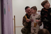 Team Minot families paint a banner during the 91st Missile Wing (MW) Family Day at Minot Air Force Base, North Dakota, April 18, 2025. The 91MW hosted the family day in honor of the Month of the Military Child. (U.S. Air Force photo by Senior Airman Alyssa Bankston)