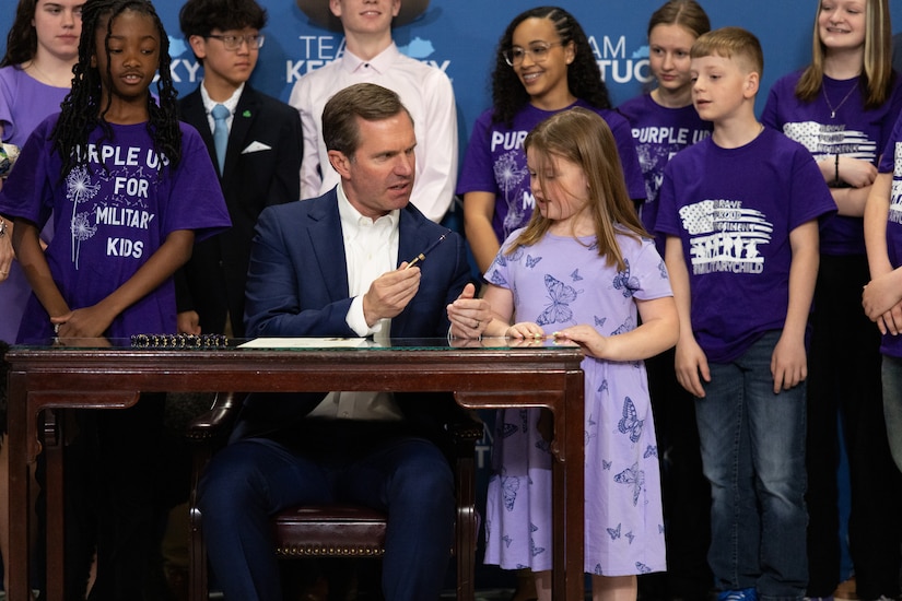Kentucky Gov. Andy Beshear shows the pen he uses to sign proclamations to the daughter of a Service member at the Kentucky State Capitol Rotunda in Frankfort, Ky., on April 17, 2025.  Beshear signed the official proclamation that April is the month of the military child to show appreciation for Service members’ families. (U.S. Army National Guard photo by Andy Dickson)