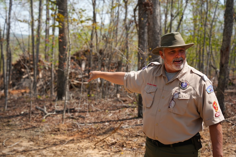 Camp Ranger Troy Williams points to a pile of debris gathered for removal at Camp Grimes in McDowell County, North Carolina., April 18, 2025. The U.S. Army Corps of Engineers is leading debris removal operations at the 1,100-acre Boy Scout camp as part of a FEMA-assigned mission following Hurricane Helene. The work is helping restore the property ahead of the upcoming summer season.
