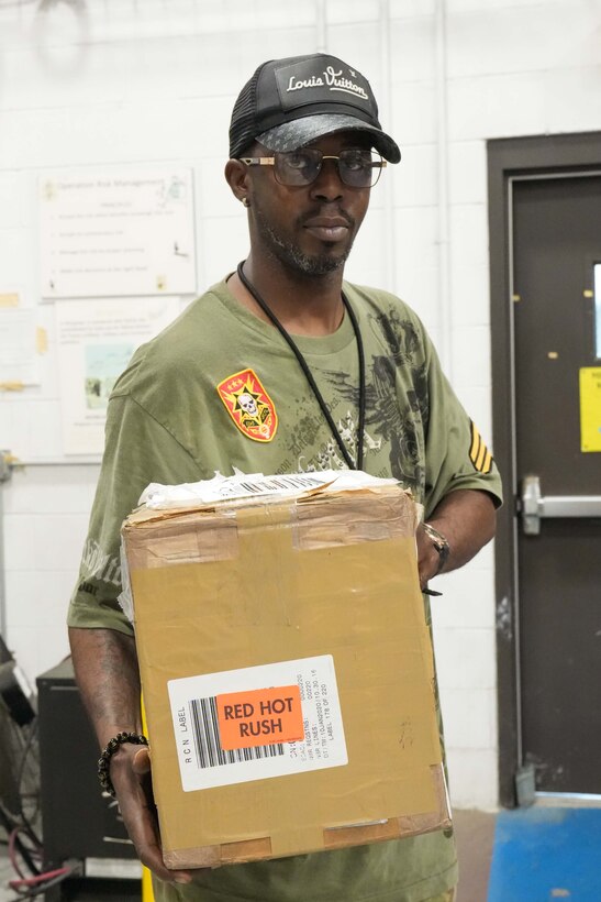 Man stands holding a box