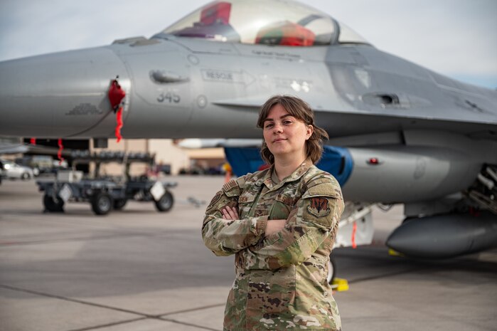 U.S. Air Force Staff Sgt. Marg Heyden, a 57th Aircraft Maintenance Squadron weapons load crew chief, stands in front of an F-16 Fighting Falcon after participating in the first quarter weapons standardization load crew competition at Nellis Air Force Base, Nevada, April 18, 2025.